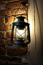 Vintage Lantern on Brick Wall - Warm Glow, Rustic Lighting Fixture, Antique Decor Royalty Free Stock Photo