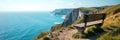Weathered bench perched on coastal clifftop; boundless sea view, natural, panorama Royalty Free Stock Photo