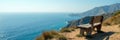 Weathered bench perched on coastal clifftop; boundless sea view, shadow, clifftop, holiday Royalty Free Stock Photo