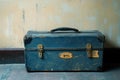 Weathered Blue Suitcase with Brass Hardware Against a Wall Royalty Free Stock Photo