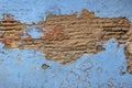 A weathered blue wall with a large chipped section exposing bricks. Royalty Free Stock Photo