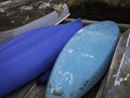 Upside down blue bottoms of kayaks and brown dinghies Royalty Free Stock Photo