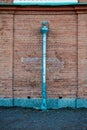 Weathered brick wall with a rusty metal drainpipe Royalty Free Stock Photo