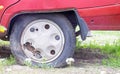 Weathered car wheel with dirt and grime. Rusty abandoned car in the parking lot. Restoration of a retro car. Flat tire. Vintage Royalty Free Stock Photo