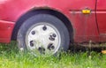 Weathered car wheel with dirt and grime. Rusty abandoned car in the parking lot. Restoration of a retro car. Flat tire. Vintage Royalty Free Stock Photo