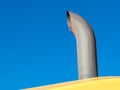 Weathered chrome exhaust stack under blue sky with copy space Royalty Free Stock Photo