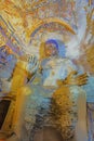 Weathered colorful Buddha statue in cave 9 of the Yungang Grottoes