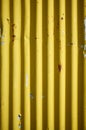 Weathered corrugated yellow rusty metal wall.