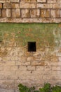 Weathered cracked brick wall with green paint stains Royalty Free Stock Photo