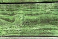Weathered cracked green color paint on rustic wooden crooked panel