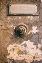 Weathered door bell and blank label on faded wall background Royalty Free Stock Photo
