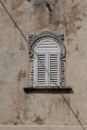 Old ornate window crossed by a shadow Royalty Free Stock Photo