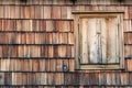 Weathered and faded from the sun wooden shingles that are the facade of an alpine house. Wooden texture in shades of gray and Royalty Free Stock Photo