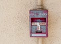 Weathered fire alarm panel on a stucco wall