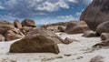 Weathered granite boulders are piled on a tropical beach.