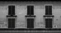 Weathered Gray Stone Building Facade with Closed Shutters Royalty Free Stock Photo