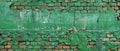 Weathered green bricks with peeling paint and cracks, revealing the texture and age of an old wall or building exterior. Royalty Free Stock Photo