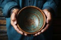 Weathered hands, empty bowl on wood backdrop, evoke the harshness of hunger Royalty Free Stock Photo