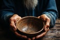 Weathered hands, empty bowl on wood backdrop, evoke the harshness of hunger Royalty Free Stock Photo