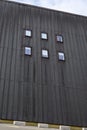Weathered industrial dark metal wall with six small windows