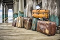 weathered luggage set by an oceanside pier