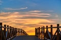 Weathered lumber path leading to calm sea during beautiful sunset Royalty Free Stock Photo