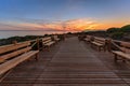 Weathered lumber path leading to calm sea during beautiful sunset Royalty Free Stock Photo