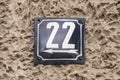 Weathered metal enameled plate of street address number 22