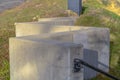 Weathered metal handrail of an outdoor stairs connected to a concrete block