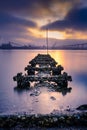 Weathered pilings point to the sunrise in San Diego bay in a long exposure Royalty Free Stock Photo