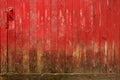 Weathered, red barn door with mud at the base. Royalty Free Stock Photo