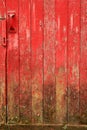 Weathered, red barn door with mud at the base. Royalty Free Stock Photo