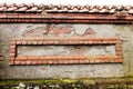 Weathered red bricks are decoratively situated in wall