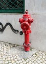 Weathered red fire hydrant near a cement wall Royalty Free Stock Photo
