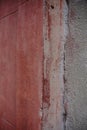 Close up of a red painted wall with visible cracks and deterioration, highlighting the effects of time and weather Royalty Free Stock Photo