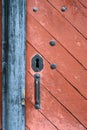 Weathered red wood door with old iron lock and handle Royalty Free Stock Photo