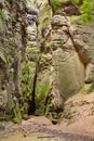 Weathered rock walls with small opening.