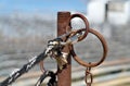 Weathered rope with clevis attached to a rusty steel pipe hitching post Royalty Free Stock Photo