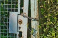 Weathered, rust-covered iron gate with a chain on a field Royalty Free Stock Photo
