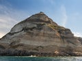 Weathered seaside rock face texture with parts of green and blue water. Aged volcanic stone wall surface background pattern Royalty Free Stock Photo