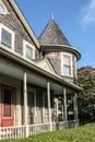 Weathered shingled house with turret and porch and red door in Cape Cod USA Royalty Free Stock Photo