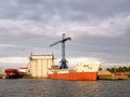 Weathered ship, crane, and crows in Lemmer harbor, Friesland, Netherlands