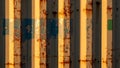 Weathered shipping container surface texture featuring peeling paint rust and dramatic vertical sunlight shadows Royalty Free Stock Photo