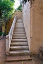 Weathered Stone Stairs Ascending Alongside an Earth-Colored Wall in a Tranquil Garden Setting Royalty Free Stock Photo