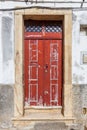 A weathered, vibrant red double door with peeling paint Royalty Free Stock Photo