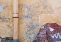 Weathered wall with a rusty metal drainpipe and worn textures Royalty Free Stock Photo