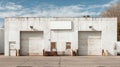 Warehouse facade with loading docks, doors, and a blank sign under a blue sky Royalty Free Stock Photo