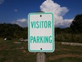 Weathered white and green visitor parking sign