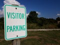 Weathered white and green visitor parking sign