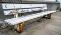 Weathered White Metal Bench with Rust on Concrete Surface in Outdoor Setting Royalty Free Stock Photo